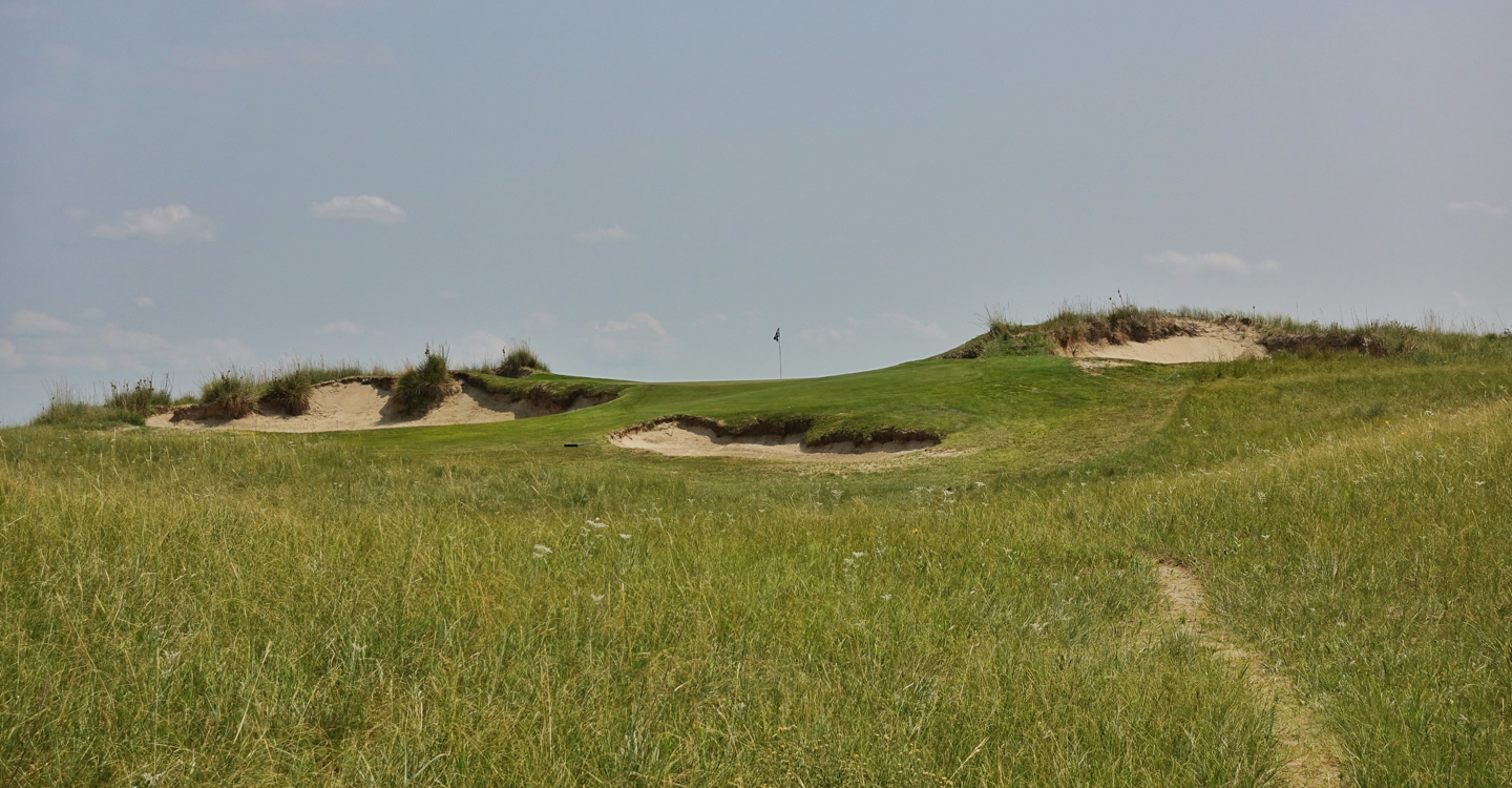 A flag, a false front and bunkers are all the player sees from the 17th tee A flag, a false front and bunkers are all the player sees from the 17th tee